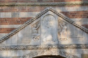 Pavia, Basilica di San Pietro Cielo d’Oro - above the front entry door - Saint Michael the Archangel and two saints