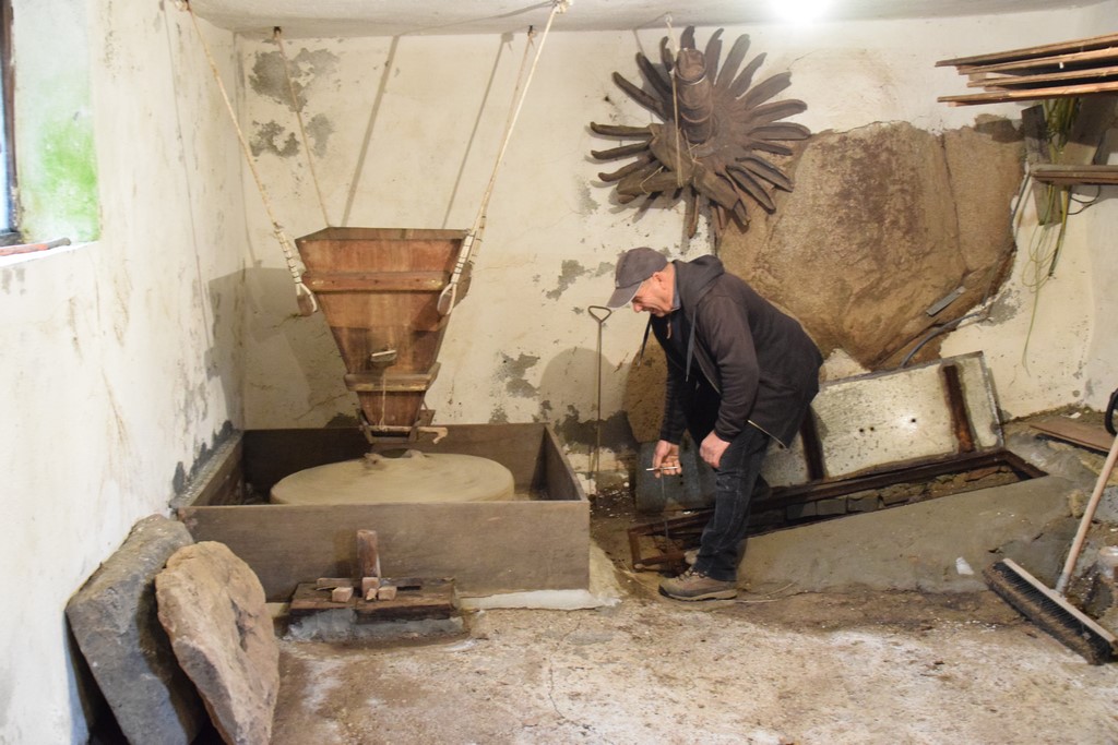 Samugheo - Mulino di Giobbe - the miller opening the sluice to demonstrate how the water is used to turn the millstones