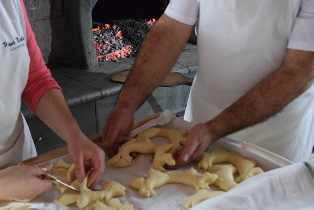 Samugheo - Pane Nostu - Giovanna Frongia shapes and snips the dough with her hands and scissors while Antonello Meloni carefully arranges the loaves on the cloth