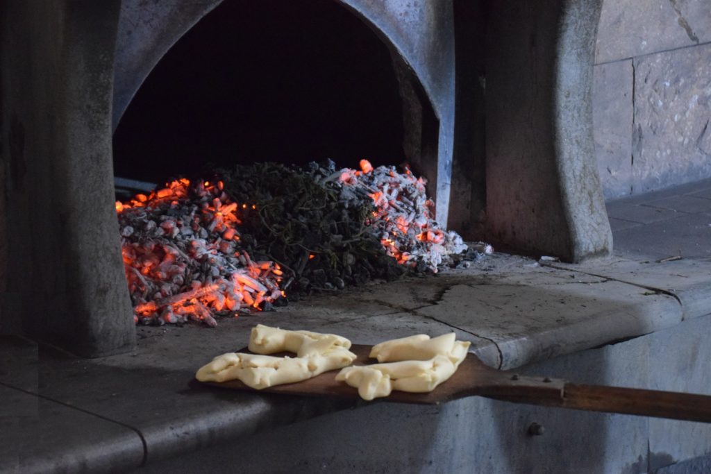 Samugheo - Pane Nostu - Antonello prepares to slide the risen loaves into the hearth. The bread is placed on the clean hearthstone behind the coals - deep inside