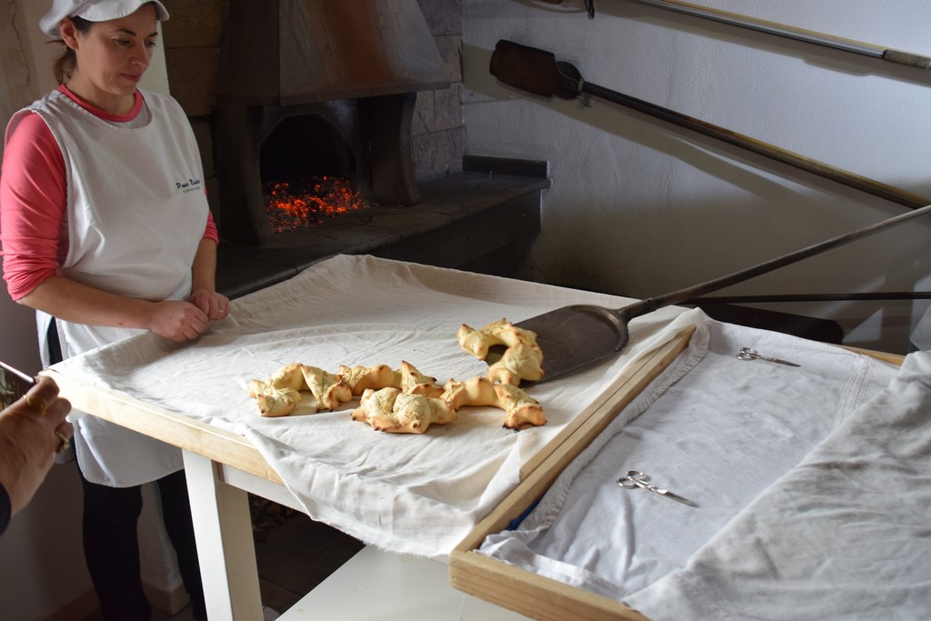 Samugheo - Pane Nostu - Antonello removes the hot bread from inside the oven while Giovanna watches